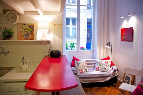 - un salon avec une lampe rouge et un canapé dans l'établissement Le Studio Flore, à Paris