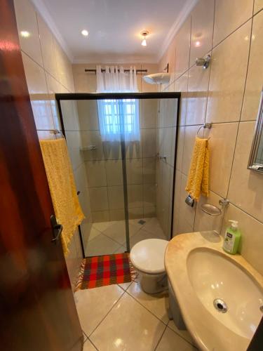 a bathroom with a shower and a toilet and a sink at Casa em cidade Histórica in Caxambu