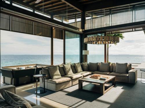a living room with a couch and a table at Park Hyatt Maldives Hadahaa in Gaafu Alifu Atoll