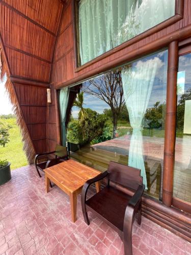 a room with a table and a bench and a window at Villa Baan Pak Pra in Ban Pak Pra (1)