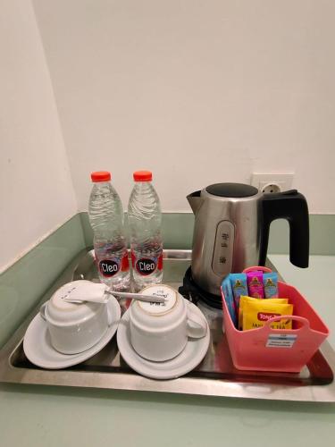 a tray with plates and water bottles on a counter at Sweet Garden Guest House in Malang
