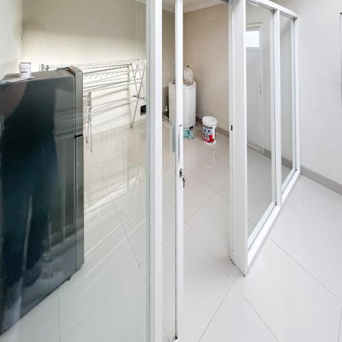a bathroom with a glass door and a toilet at Queen Belt Mitra Reddoorz in Balong
