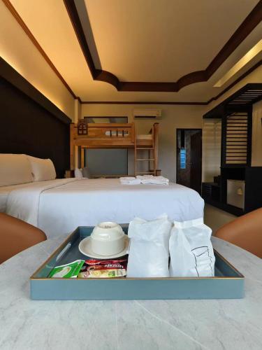 a bedroom with a bed with a tray of food at Blue Carina Hotel Phuket in Phuket Town