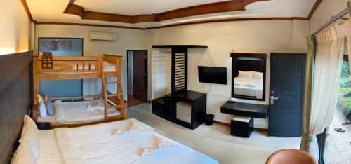 a room with two bunk beds and a television at Blue Carina Hotel Phuket in Phuket Town