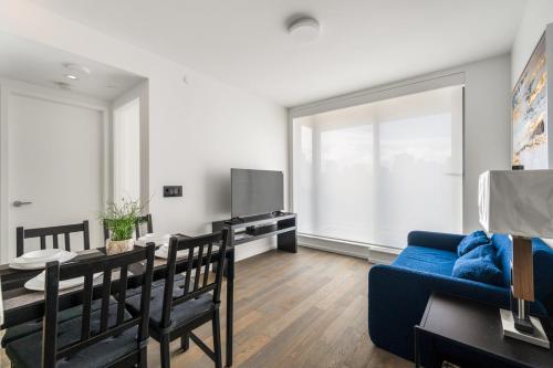 a living room with a blue couch and a table at Luxury High-Rise Condo with Stunning Views in Vancouver