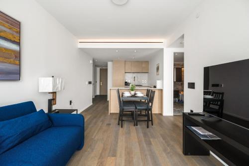 a living room with a blue couch and a table at Luxury High-Rise Condo with Stunning Views in Vancouver