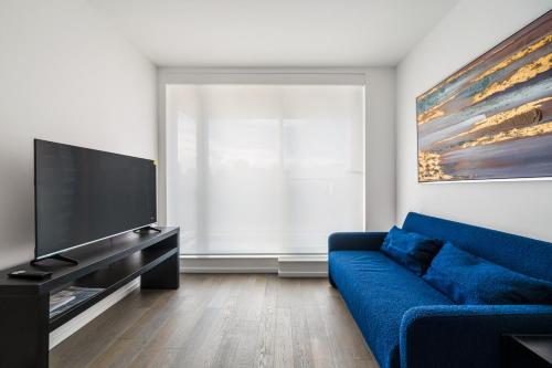 a living room with a blue couch and a flat screen tv at Luxury High-Rise Condo with Stunning Views in Vancouver