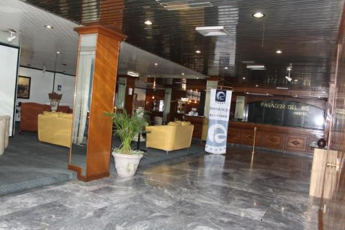 a lobby with yellow furniture and a potted plant at Parador del Río by Flamingo Hotels Group in Irapuato