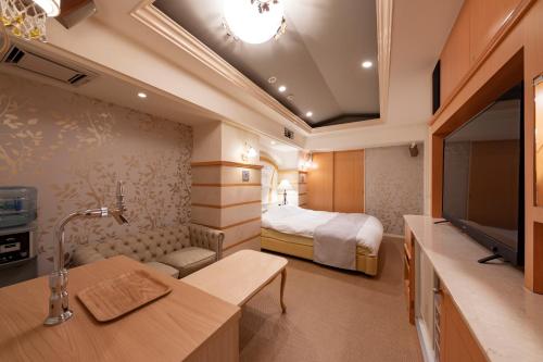 a hotel room with a bed and a television at Hotel Luna Sendai -Adult Only in Shimo-ayashi