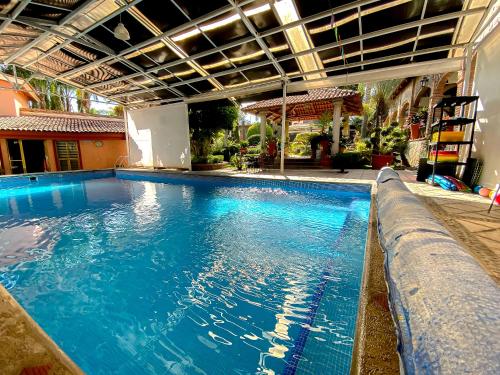 a large pool with blue water in a building at Hotel El Dorado - cerca de Chapala y del Aeropuerto in Ixtlahuacán de los Membrillos