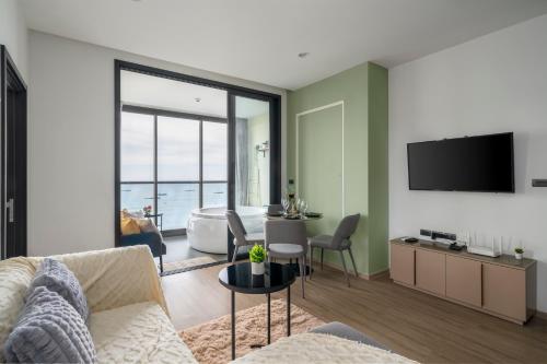 a living room with a couch and a television at Vacaystation Edge Central Pattaya in Pattaya Central