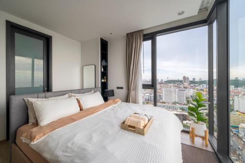 a bedroom with a large bed and large windows at Vacaystation Edge Central Pattaya in Pattaya Central