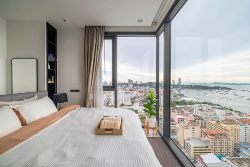 a bedroom with a large bed and a large window at Vacaystation Edge Central Pattaya in Pattaya Central