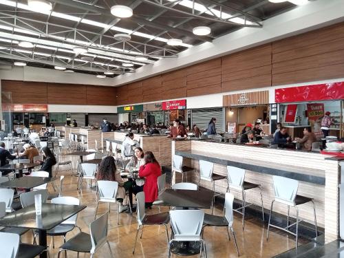 a group of people sitting at tables in a restaurant at AH/ Loft panorámico Industrial, Wifi350Mg, Usaquén in Bogotá