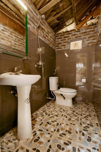 a bathroom with a sink and a toilet at Maison De Mai Hich in Mai Châu