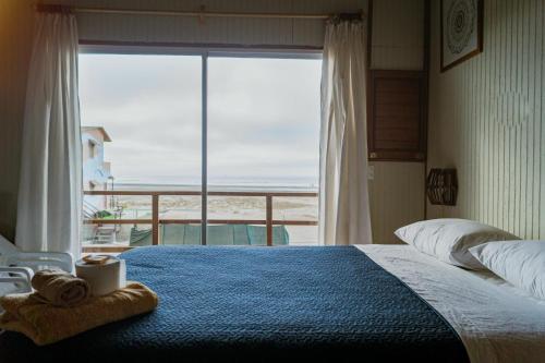 a bedroom with a bed with a view of the ocean at Punta Ngritos wind & surf in Negritos