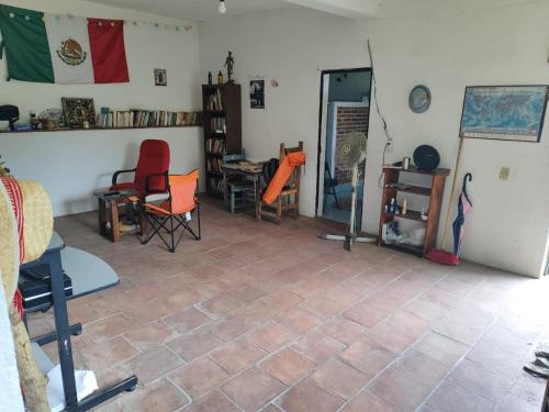 a living room with chairs and a refrigerator at Casa de la Rosa in Malinalco