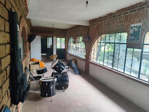 a room with chairs and windows in a brick wall at Casa de la Rosa in Malinalco