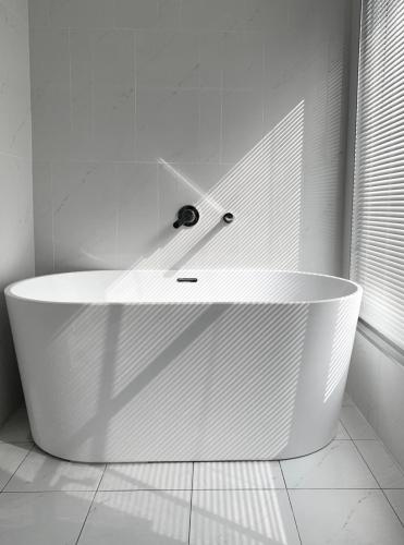 a white bath tub in a bathroom with a window at Yama no Shita Homestay in Zhongpu
