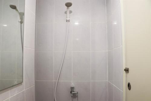 a bathroom with a shower with a shower head at Compact and Tidy Studio at Tokyo Riverside PIK 2 Apartment By Travelio in Rawalembang