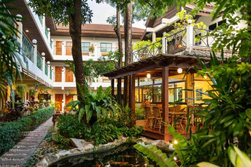a house with a pond in front of it at Charlie House Pin Klao in Bangkok