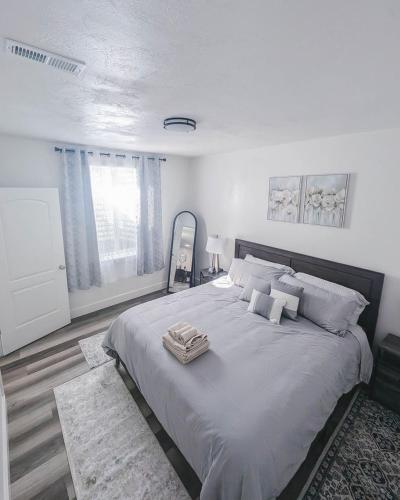 a white bedroom with a large bed with pillows at TSDLS Hometel in Smithfield
