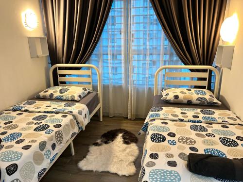 a bedroom with two beds and a cat laying on the floor at Cozy Family Condo in Petaling Jaya