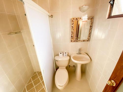 a small bathroom with a toilet and a sink at Hotel El Dorado - cerca de Chapala y del Aeropuerto in Ixtlahuacán de los Membrillos