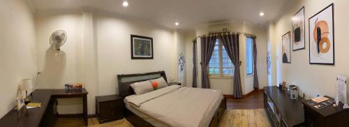 a bedroom with a bed and a desk and a window at Lava Homestay Hải Phòng in Hai Phong