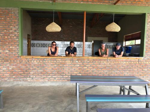 a group of people sitting at a bar at Inzozi Eco Camp in Gishyita