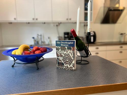 a bowl of fruit and a bottle of wine on a counter at Villa LakePlats in Östersund