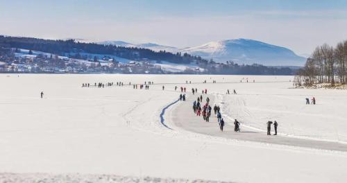 a group of people walking across a snow covered field at Villa LakePlats in Östersund