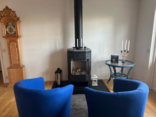 a living room with blue chairs and a fireplace at Villa LakePlats in Östersund