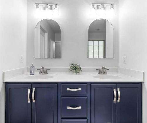 a bathroom with two sinks and two mirrors at The Gate 4 Getaway! in Oak Grove