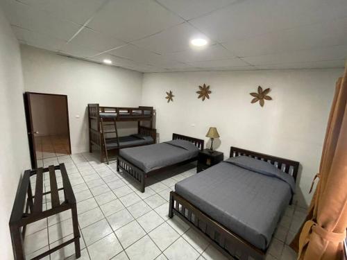 Un dormitorio con dos camas y suelo de baldosas. en Apaneca House, en Apaneca