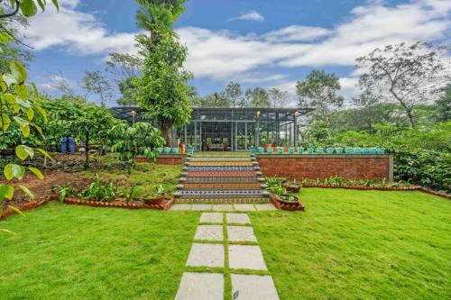 a garden with a building in the background at Magnolia Estates & Resorts in Virajpet