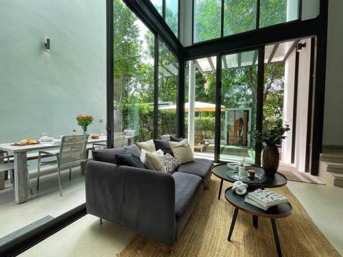 ein Wohnzimmer mit Sofa und Tisch in der Unterkunft Forest Hill Residences Koh Samui Villa Alaia 3bd, 5 min walking from Fishermans Village in Koh Samui 