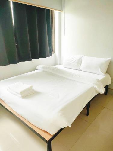 two beds in a room with white sheets and pillows at X Mitr Inn Nimman มิตร อินน์ นิมมาน 12 in Chiang Mai