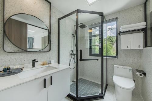 a bathroom with a shower and a toilet and a mirror at 安吉季意民宿 Jiyi Boutique Homestay, Anji, Huzhou in Anji