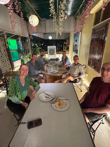 a group of people sitting at a table in a restaurant at Max Guest House in Agra