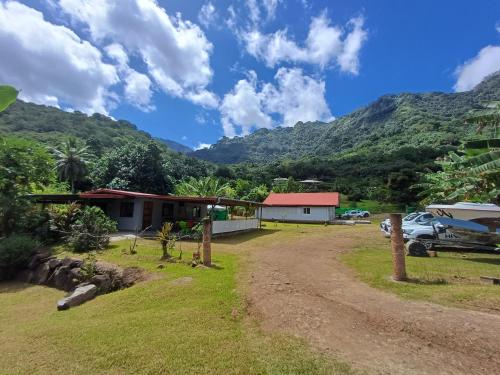 a view of a house with mountains in the background at Pitake Lodge 1 in Nuku Hiva