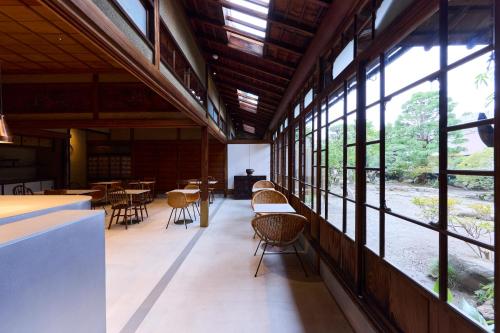 a large room with windows and tables and chairs at Hariso in Sendai