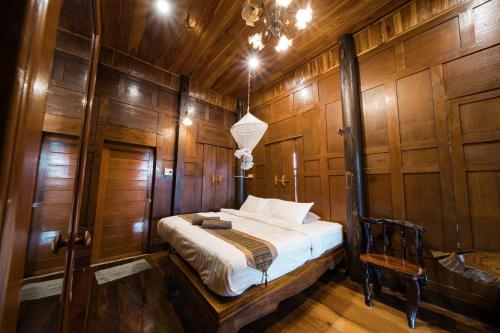 a bedroom with a bed in a wooden wall at Athithara Homestay in Phra Nakhon Si Ayutthaya