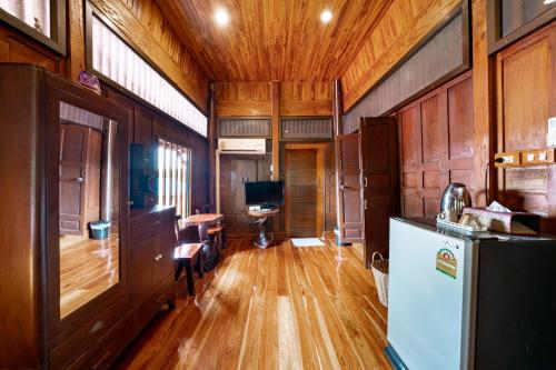a kitchen with wooden floors and a refrigerator in a room at Athithara Homestay in Phra Nakhon Si Ayutthaya
