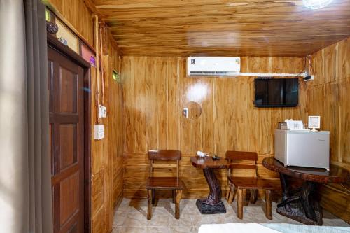 a small room with a table and chairs and a television at Athithara Homestay in Phra Nakhon Si Ayutthaya