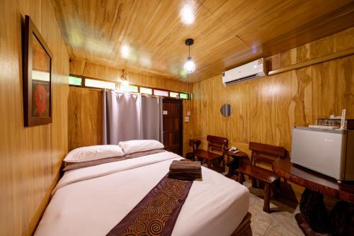 a bedroom with a bed in a room with wooden walls at Athithara Homestay in Phra Nakhon Si Ayutthaya
