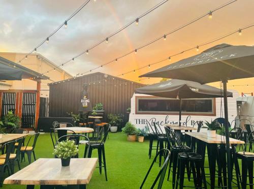 an outdoor restaurant with tables and chairs and umbrellas at Queensland Hotel in Goondiwindi