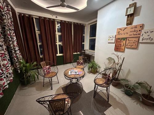 a room with tables and chairs and potted plants at Max Guest House in Agra