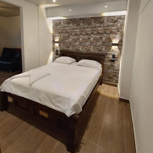 a bedroom with a large bed with a brick wall at El santorini colombiano en Doradal in Puerto Triunfo