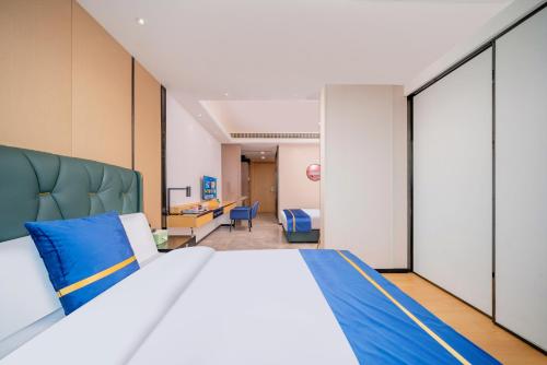 a bedroom with a large bed with a blue headboard at Cloudy international apartment Beijing Rd A-mall in Guangzhou
